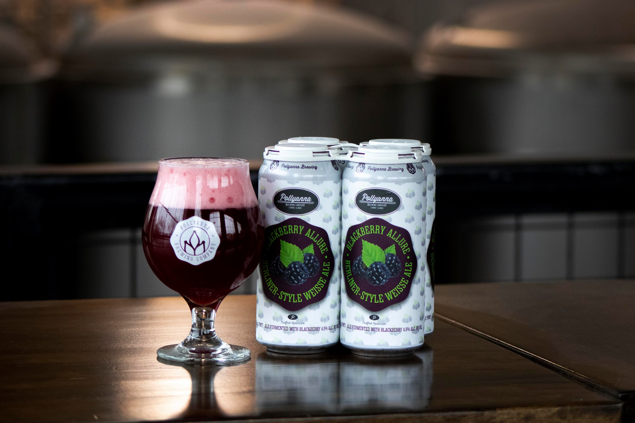 4 cans and a glass of Pollyanna Brewing Company's Blackberry Allure