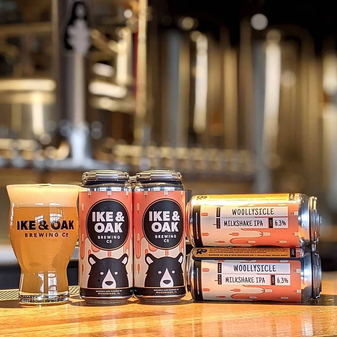 Cans of Ike and Oak Brewing's Woollysicle, next to a glass of the beer