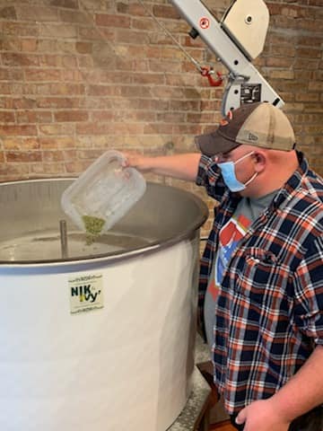 brewer pouring something into brewing vessel