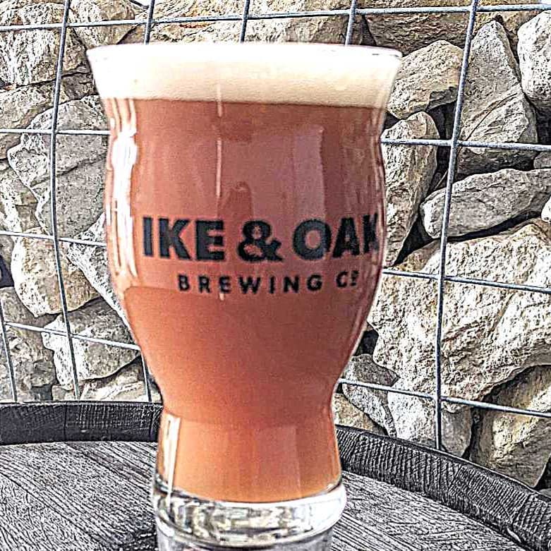 Glass of beer on a barrel outside Ike & Oak Brewing Co.