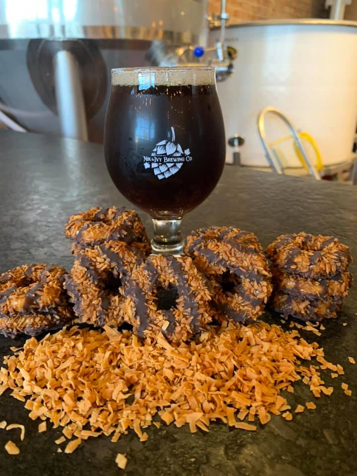 Dark ale in a glass, surrounded by cookies and toasted coconut at Nik & Ivy Brewing in Lockport, IL